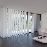 moderne, dezente Fensterdekoration durch eine breite Vertikallamellenanlage mit der Möglichkeit des individuell einzustellenden Lichteinfalls