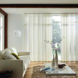 moderne Fensterdekoration in Form einer breiten Vertikal-Lamellenanlage erhältlich in verschiedenen Lamellenbreiten und Designs