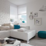 moderne, passend angefertigte Faltrollos zum individuellen Verstellen kombiniert mit einem modern bezogenen Sofa und farblich akzentuierten Kissen